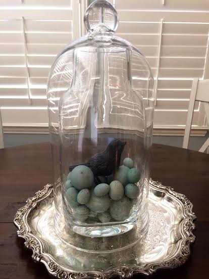This is a glass piece with a cloche over top set on an antique silver tray 