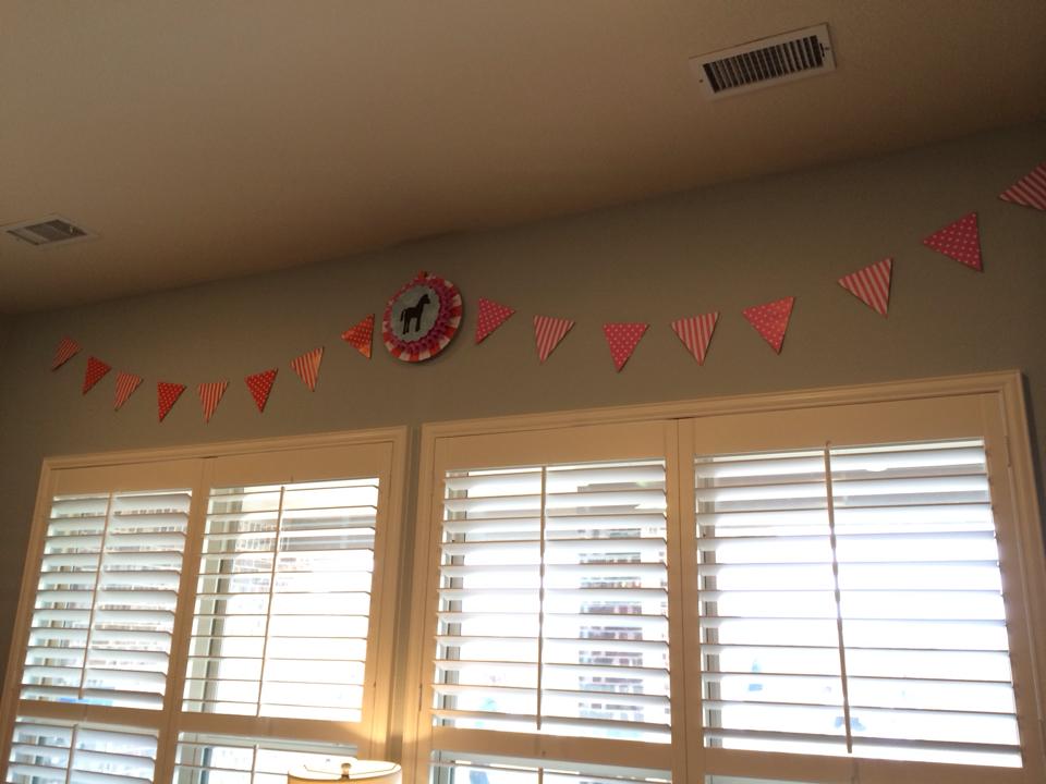 Oriental Trading has these striped and polka dot (double-sided) pennant banners in every color imaginable for around $3. I did two pennants here with a medallion I made in the middle. I also love the hanging paper fans from Oriental Trading, also super inexpensive. One of my tricks is to stack and hot glue the fans together-- so here I have a small one mounted on top of a medium. In the center I glued on a little horse silhouette that I made on the Cricut. 
