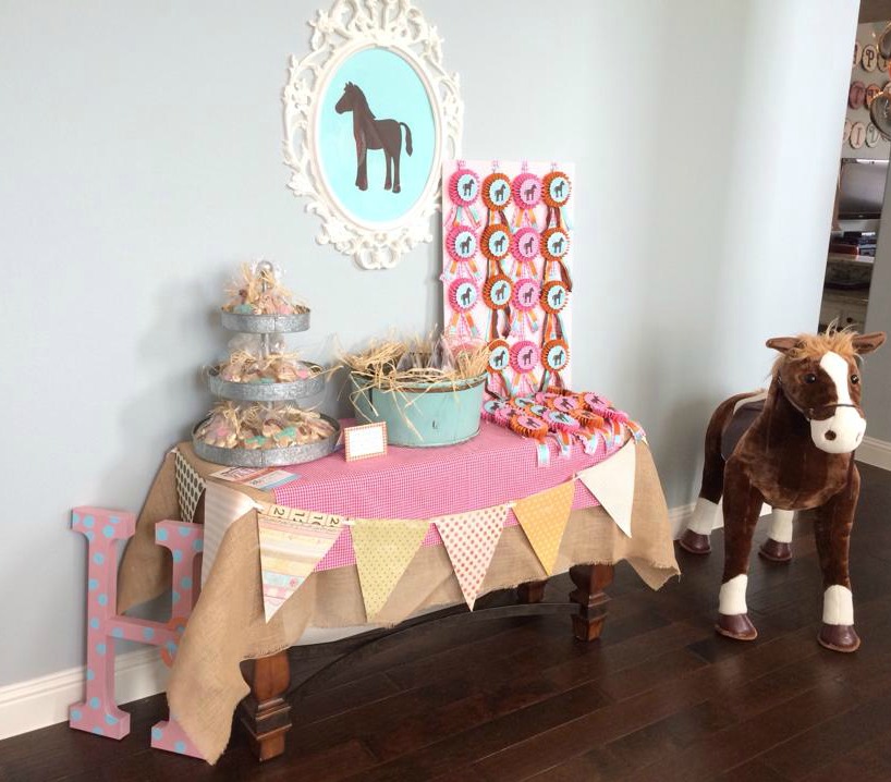 This favor table in my front entry was one of my main decor areas for this party. An heirloom painting generally hangs on the wall over this table, so it was a bit of a decision for me to decide to move it for the party, but I'm glad I did. The frame over this table is from Ikea and then I cut out the horse silhouette on my Cricut. The horse ribbons on the right are all made out of paper and ribbon and I made them all-- again using my Cricut for the horse silhouette on top. I just love how this little space came together and set the tone for the whole party. I also made the paper pennant banner on the front of the table with my Cricut as well. 