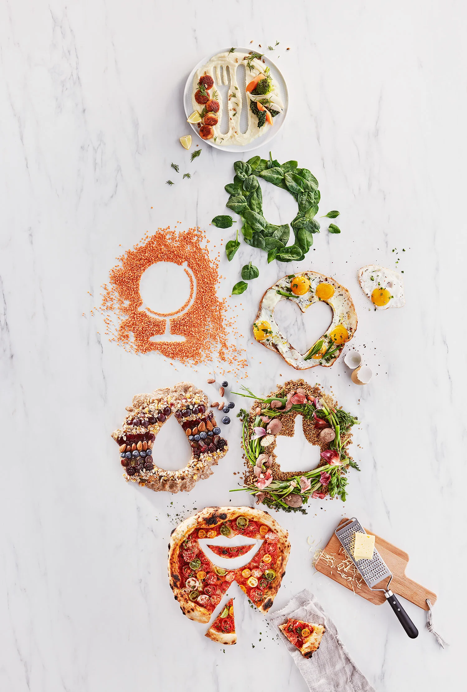 En serie av kreativa pizzor formade som olika ansikten och figurer, prydda med olika pålägg som grönsaker, kött och ost, på en vit marmorbakgrund.