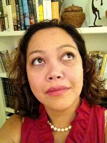 Tish Vallés looking upward, photographed at a Paris poetry salon