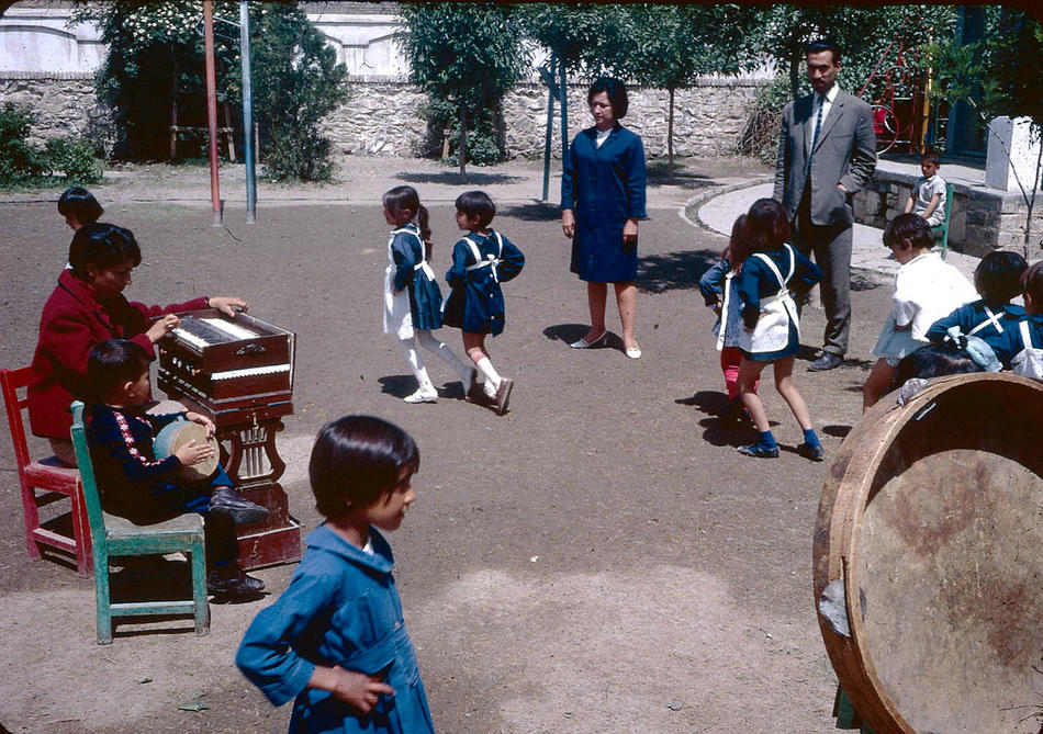 Young students dancing to music on a school playground.