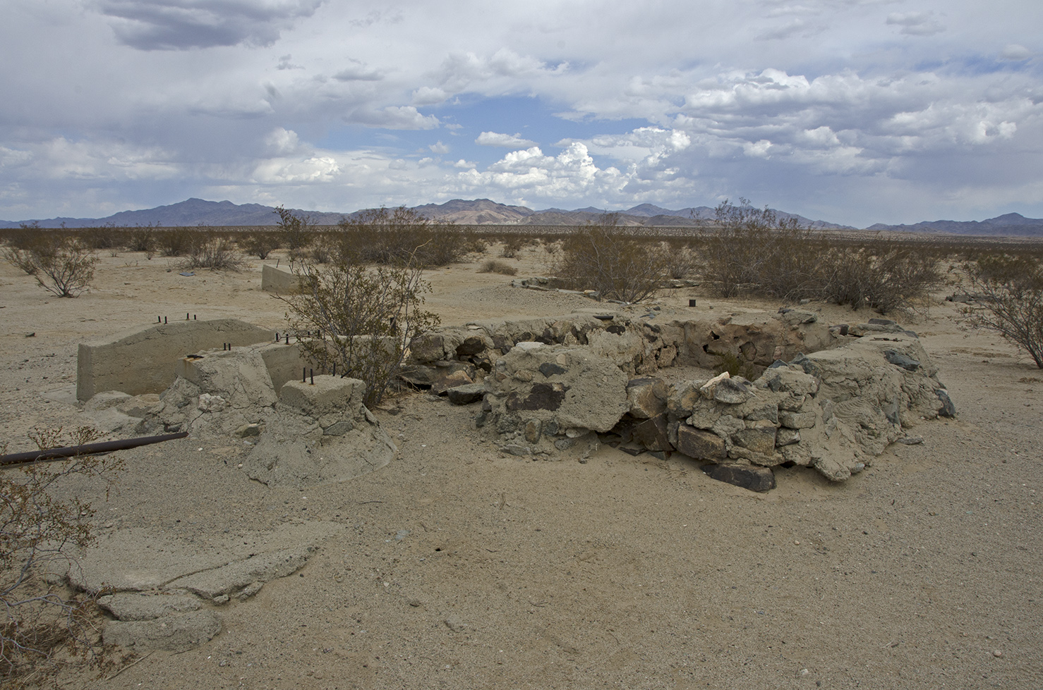 This appears to be a vat of some kind, the stone walls filled with cement are about two-feet high. It has a dirt floor. Maybe it was a public watering hole at some time.