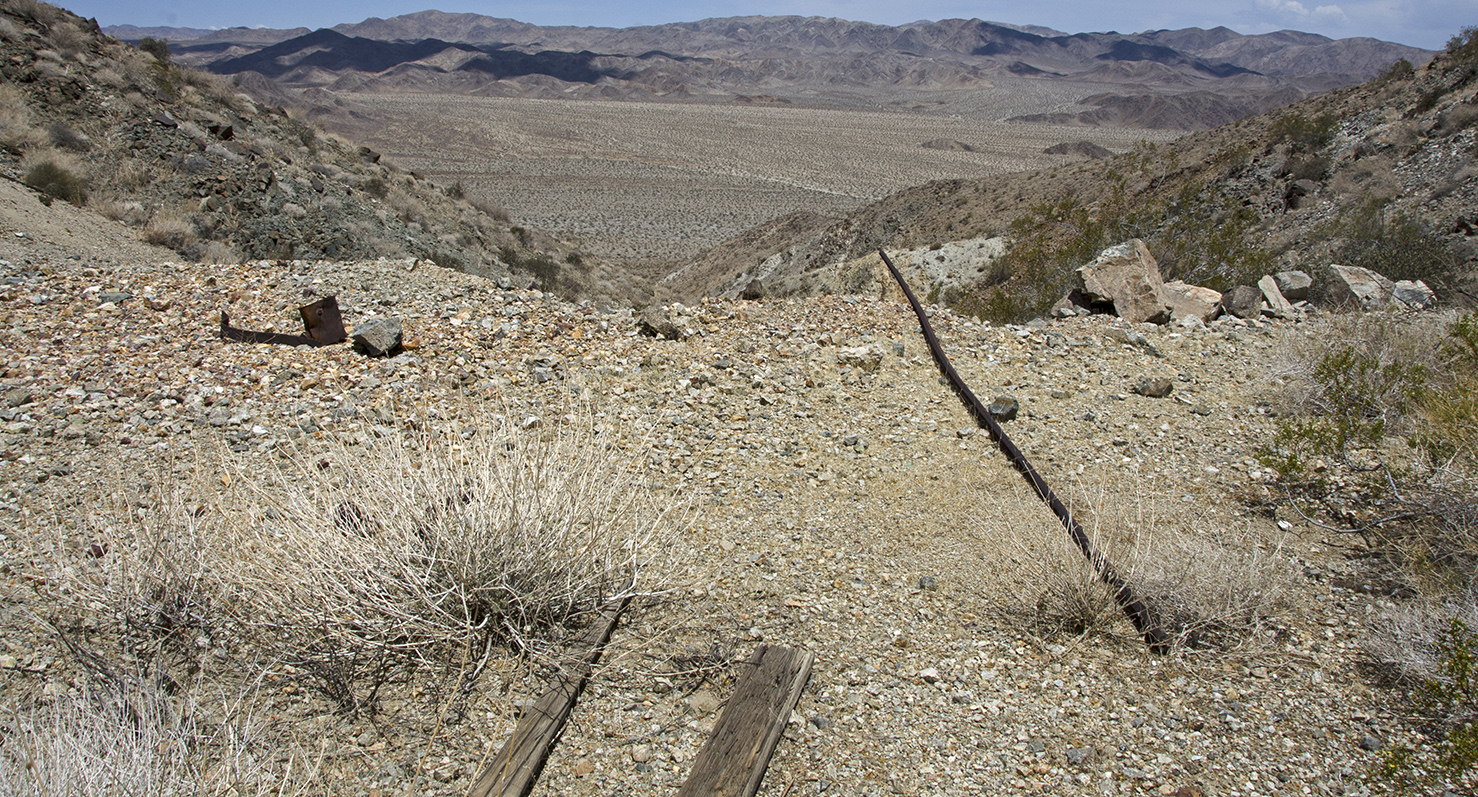 A lone piece of rail hangs over the edge, in front of the ore bin.