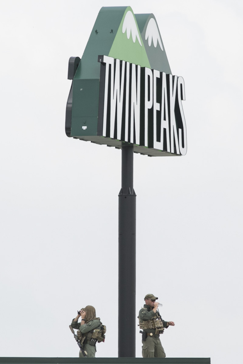 Snipers keep watch from the roof of Twin Peaks restaurant in Waco, Texas, following a motorcycle gang shootout that resulted in the death of nine bikers.