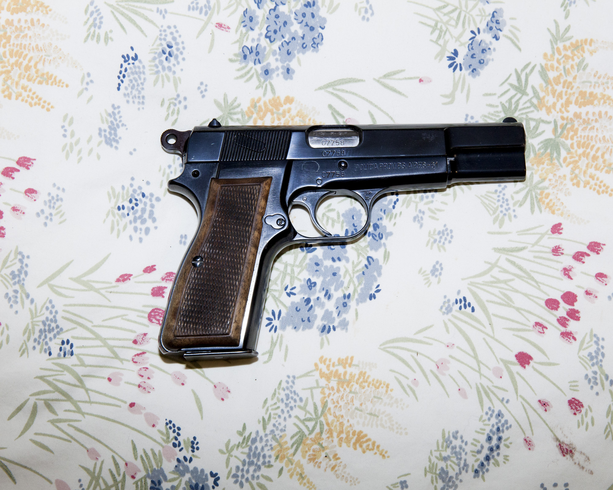  A gun lays on the floral bedspread of a Dallas-area doomsday survivalist, also known as a "Prepper". 