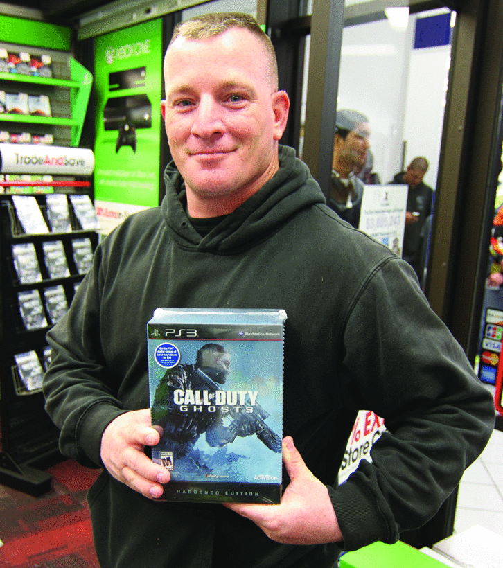 Sergeant Shane Perry of the 401st Military Police Company displays his new Call of Duty: Ghosts game during the midnight release at the Clear Creek Post Exchange GameStop. (Photo courtesy of Sergeant Cody Barber, 11th Public Affairs Detachment.)