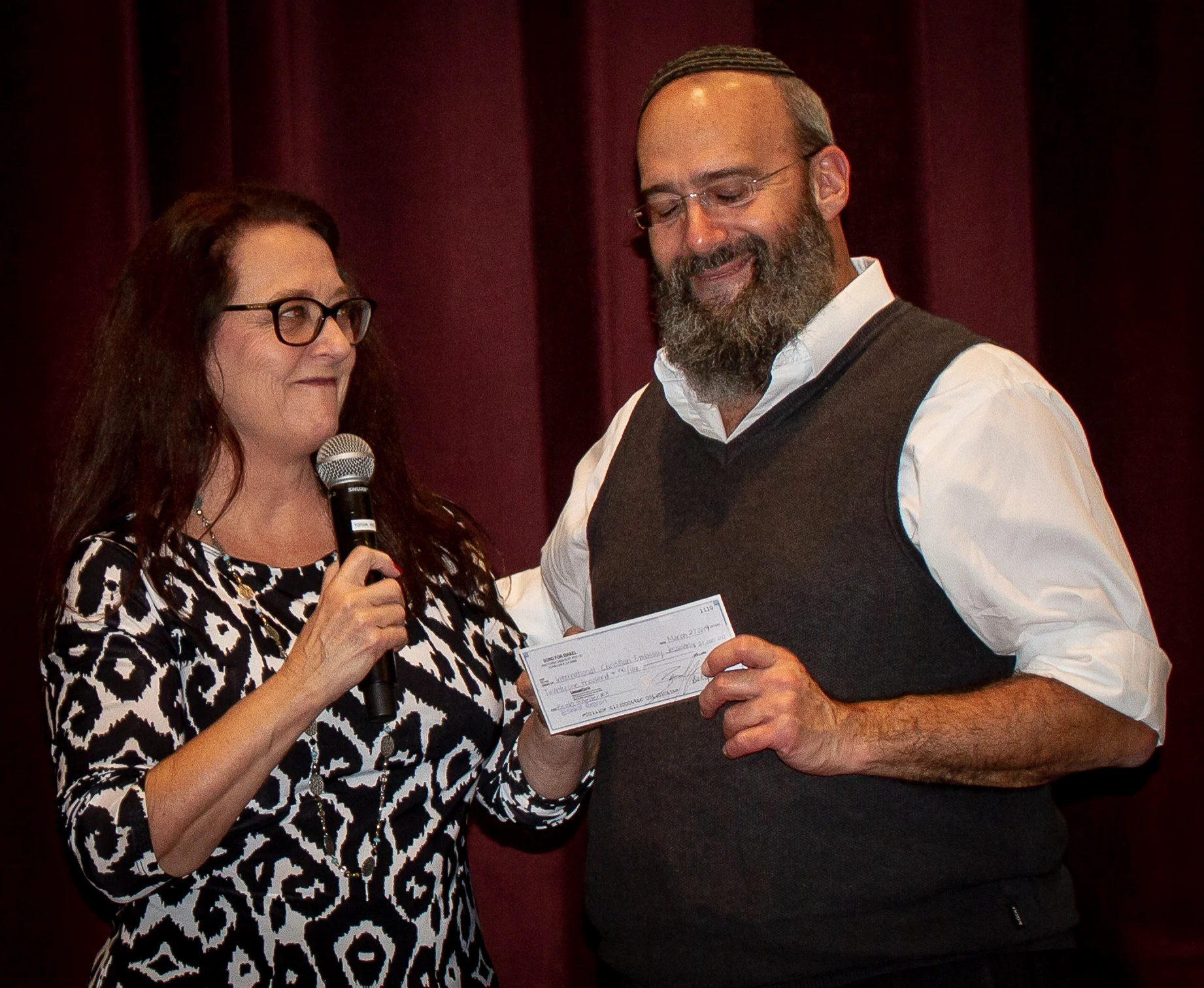 Deby Brown hands Shmuel Bowman a donation of $21,000 for a Bomb Shelter in Israel