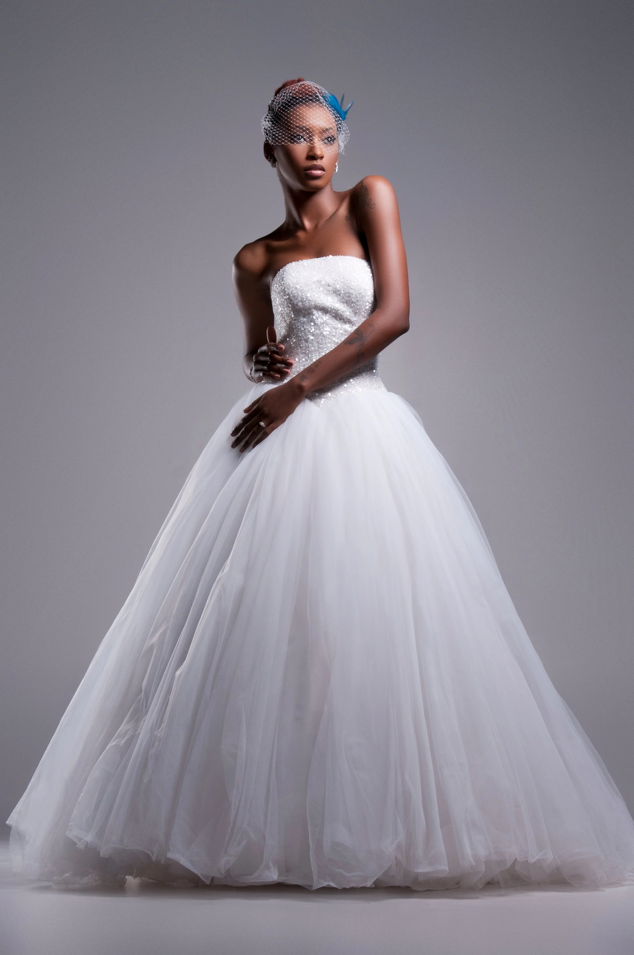 Full-length bride in a strapless ballgown with braided updo, studio portrait