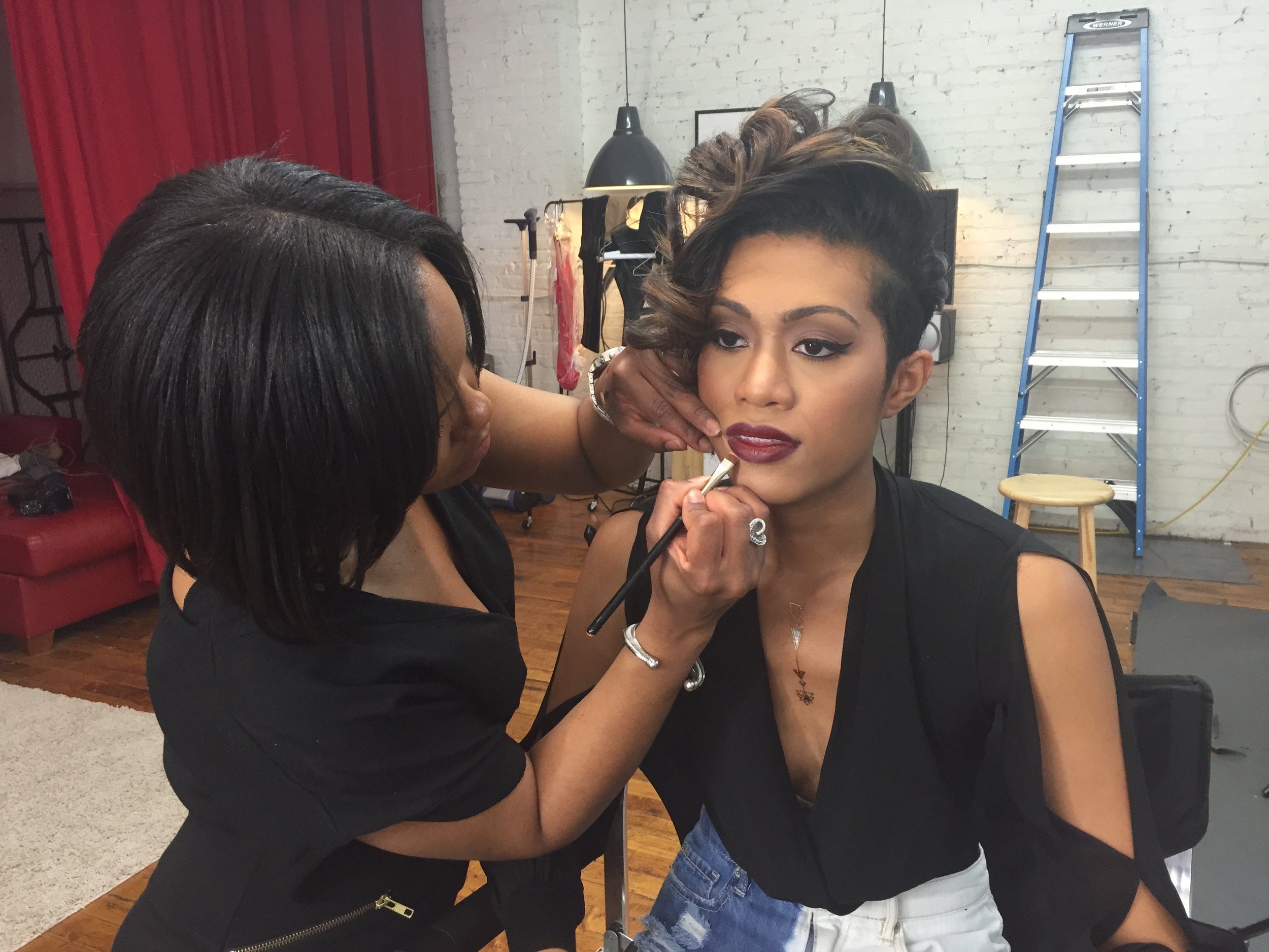 Keena Queen applying lip liner to a model in the studio