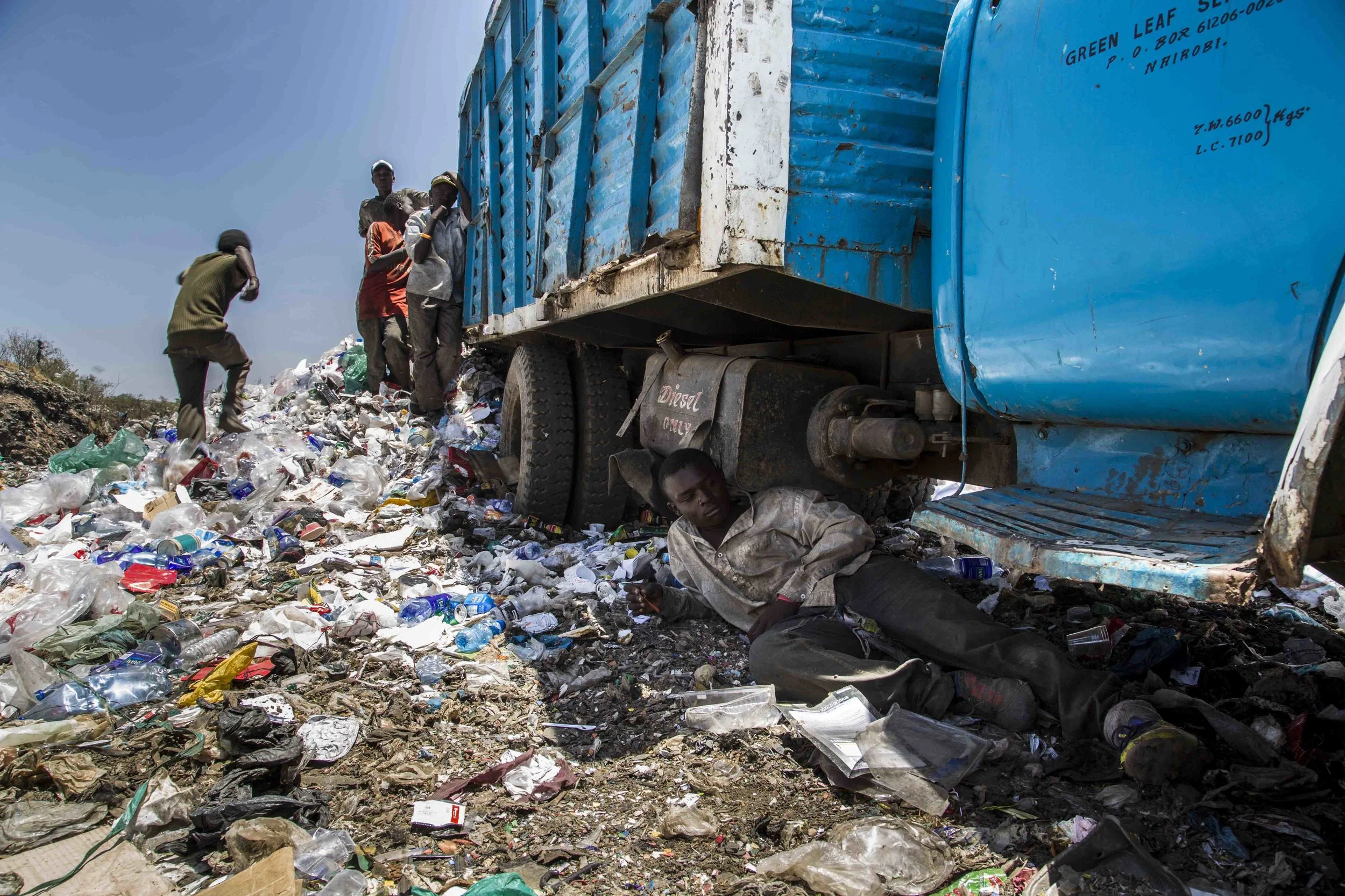 Mike Njuguna, 17 catches some shade while breaking from collecting plastics at the Dandora Dumpsite.