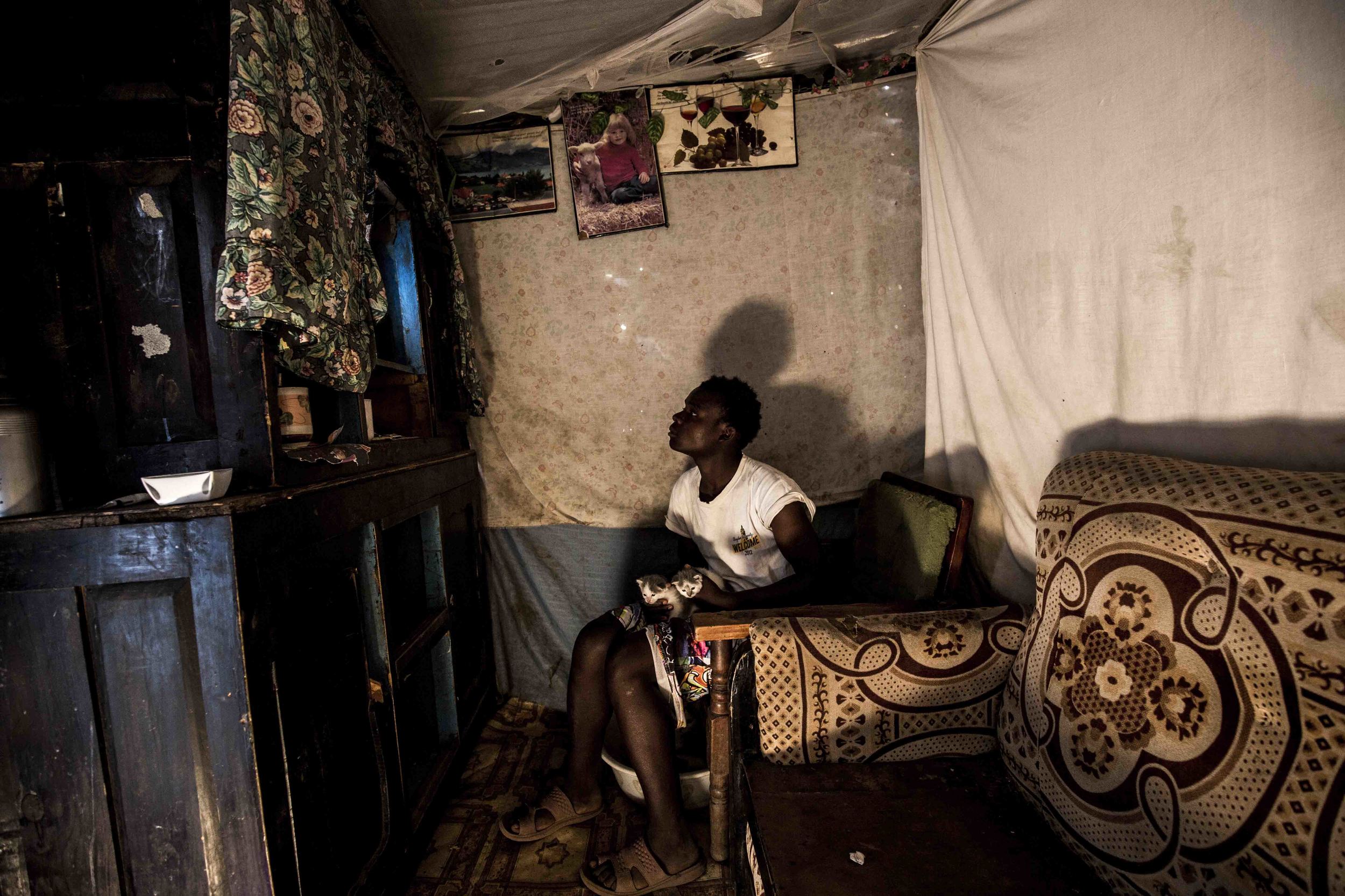  Before embarking on his daily commute from his home in Mali Saba Village to the Dandora Dumpsite, Mike Njuguna watches a rerun of  Winnie the Pooh  with his kittens. 