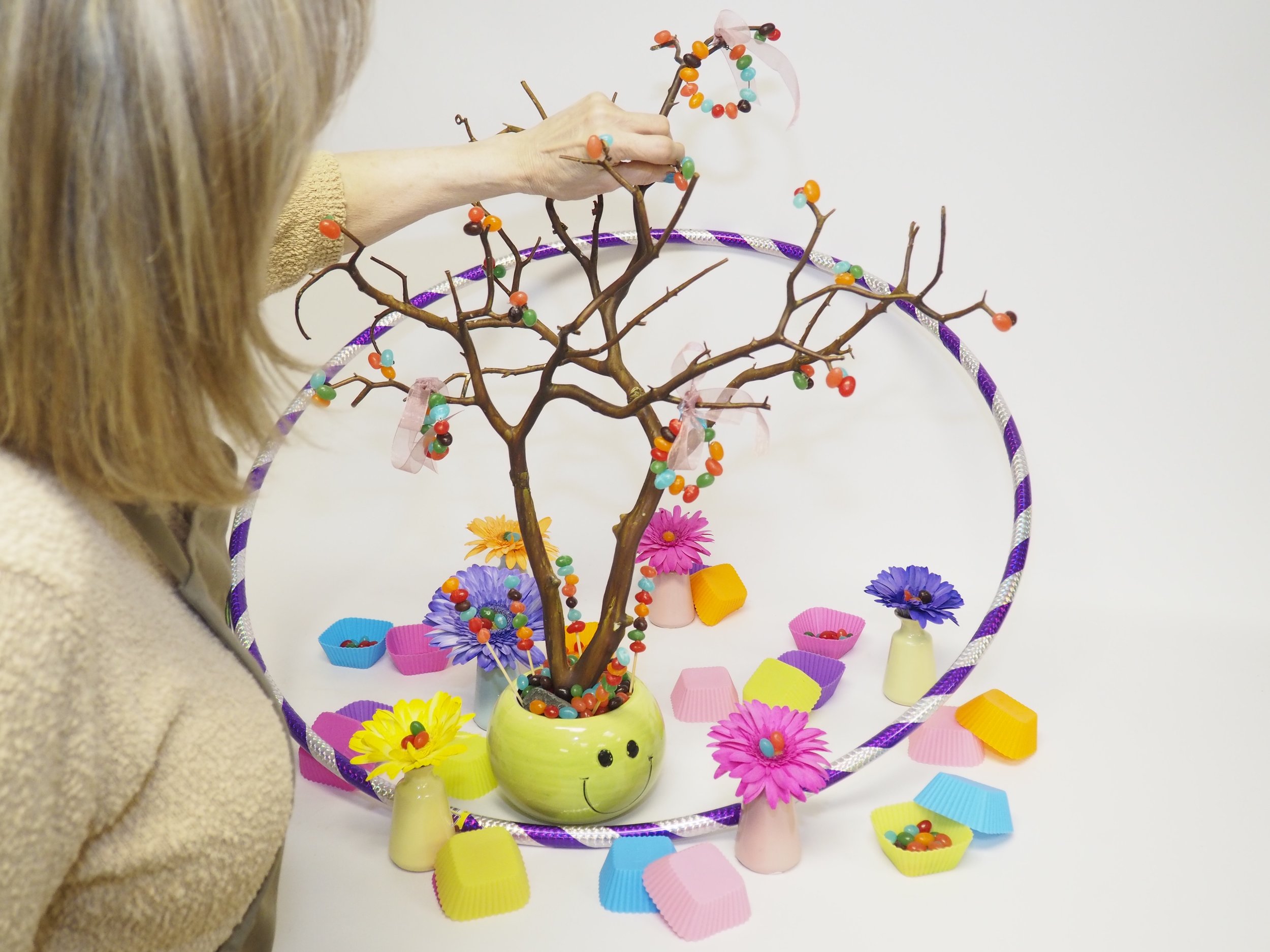 Ardith placing bean on branch with blue 