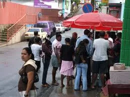 Popular doubles vendors will have a crowd around. "One for here, one for take-away" and they sell out early.