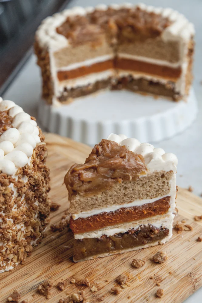 One layer of pumpkin, one spice cake, one pecan pie, frosted together with buttercream and topped with apple pie filling. Yum!