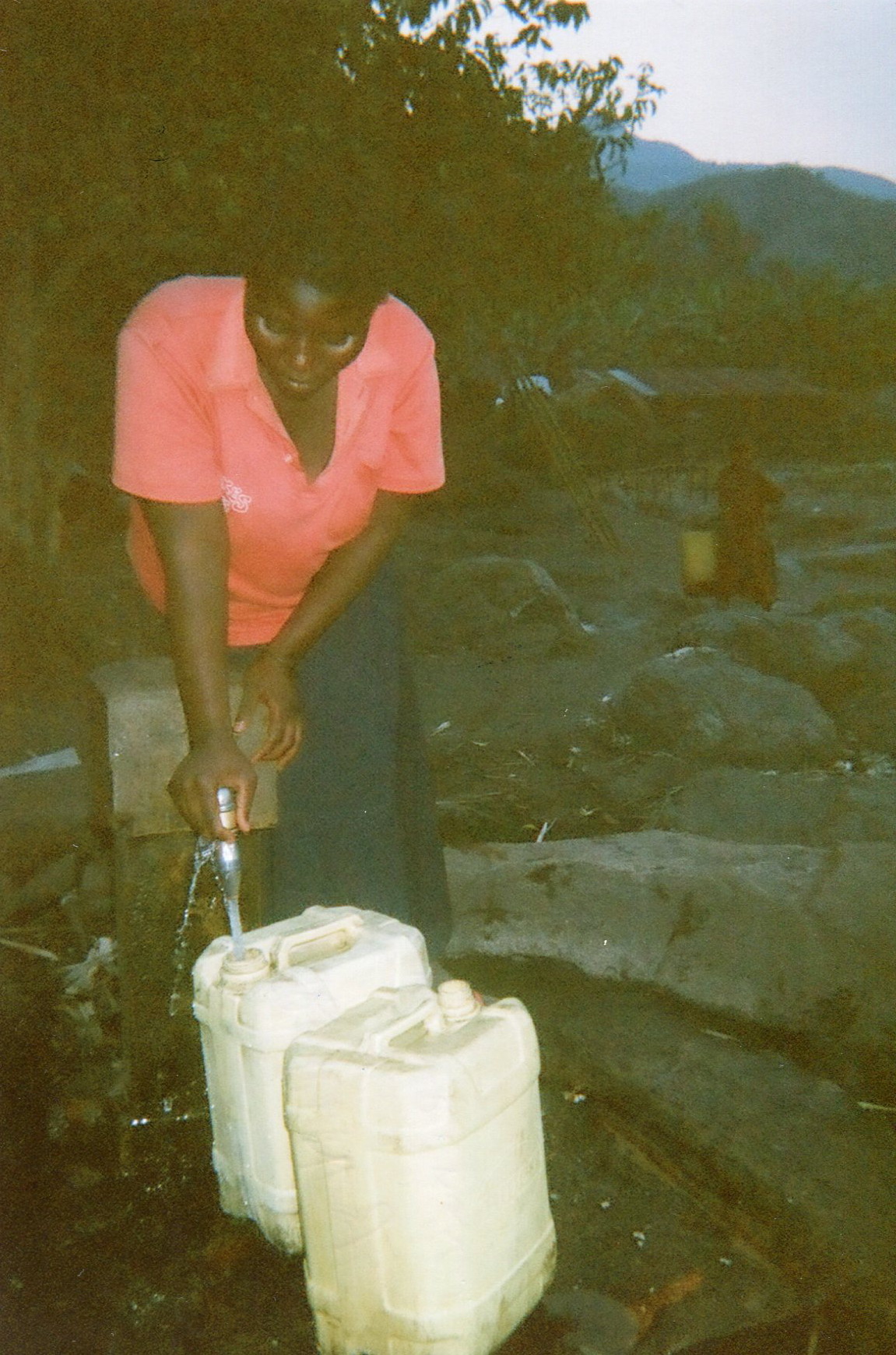  Here I am collecting water from the tap to take to the forest to wash the dishes and for drinking.   