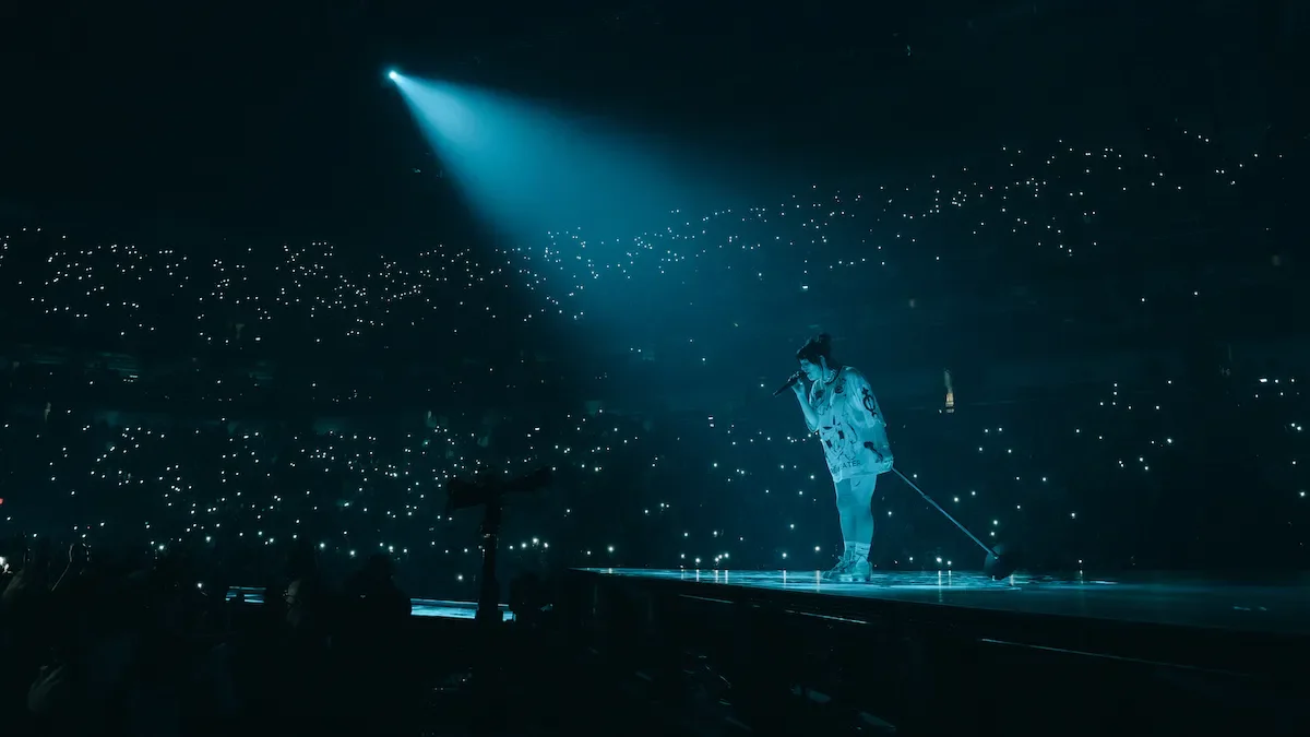 Billie Eilish performing on her “Happier Than Ever” tour in New Orleans, captivating the crowd with her signature visual