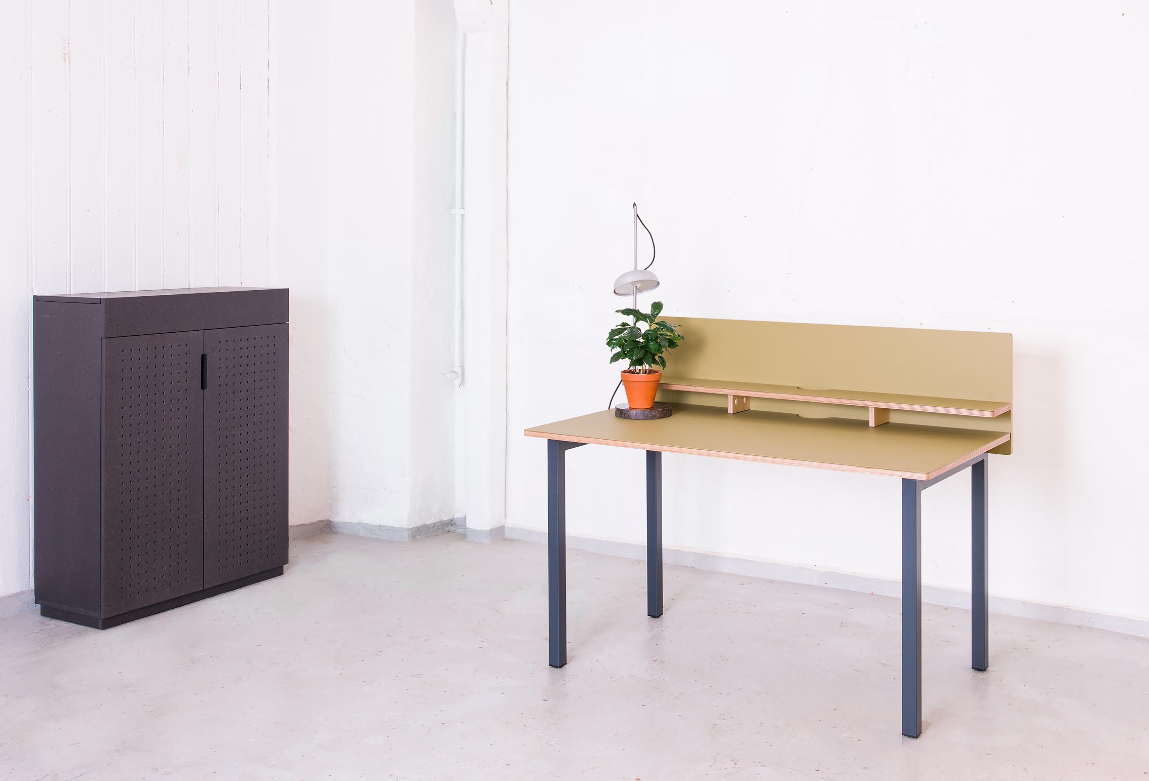 On the picture is a custom cabinet in solid anthracite Valchromat - with perforated fronts for sound absorption, designed by Norwegian interior architect Ellen Ledsten - along with Hallgeir Homstvedt's UT desk and the KI light.