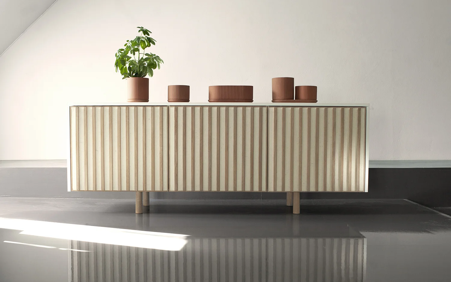Klorofyll table pots in Terracotta - designed by Anderssen & Voll + dB Silent sideboard by Jonas Stokke and Øystein Austad of StokkeAustad, featuring thick acoustic wool felt in the held in place by solid oak wood slats.
