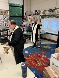 Father Ryan and Father Bob blessing Ms. Smith's classroom.