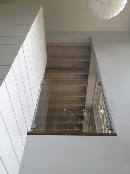 Shot of glass guardrail looking up from bottom of stairwell.
