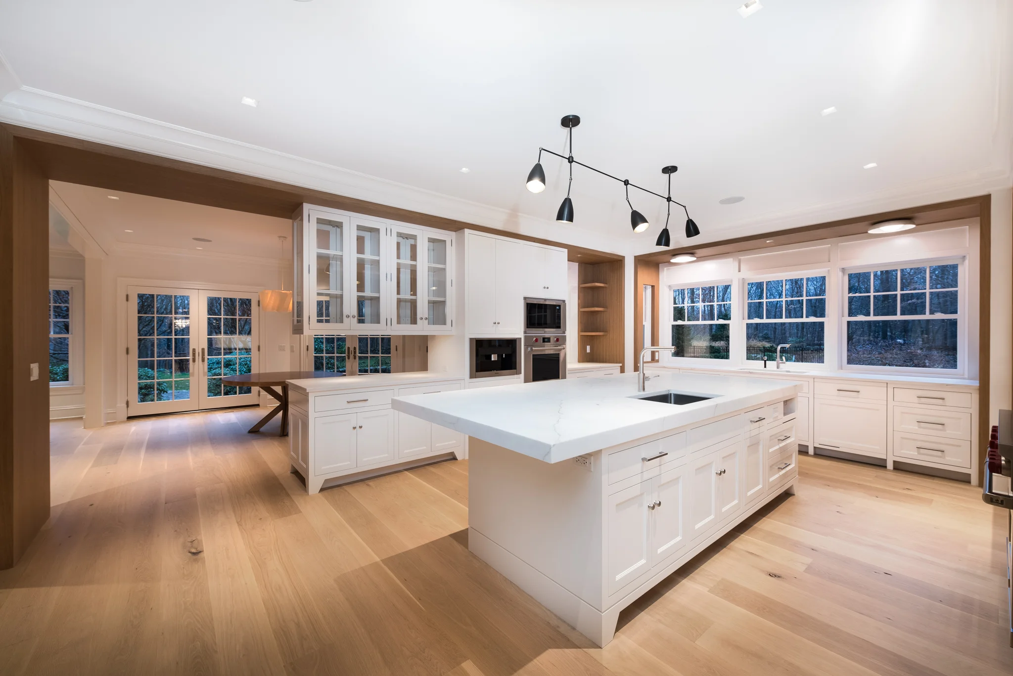 KITCHEN: The Kitchen was designed with these white-oak "frames" with the painted white cabinetry set into the frames. These frames are finished to match the adjacent Family Room fireplace and various white oak countertops used throughout the house.