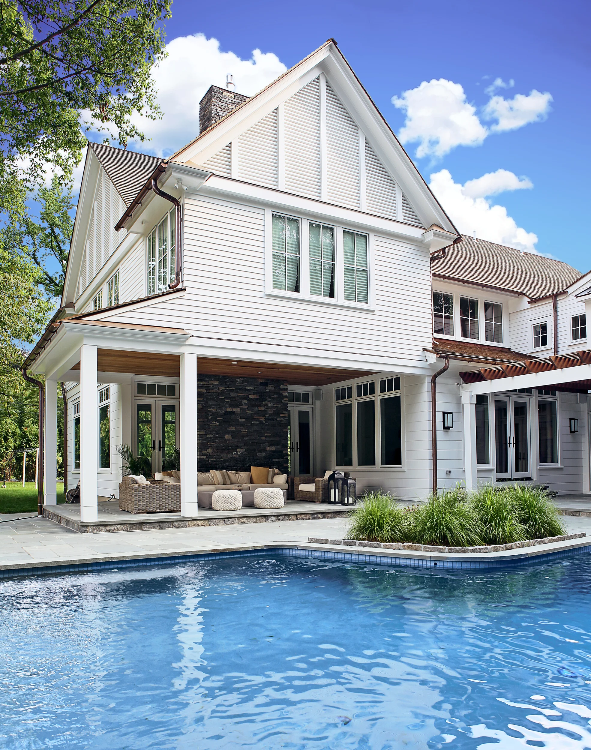 On the rear, a covered terrace overlooks the existing pool. 