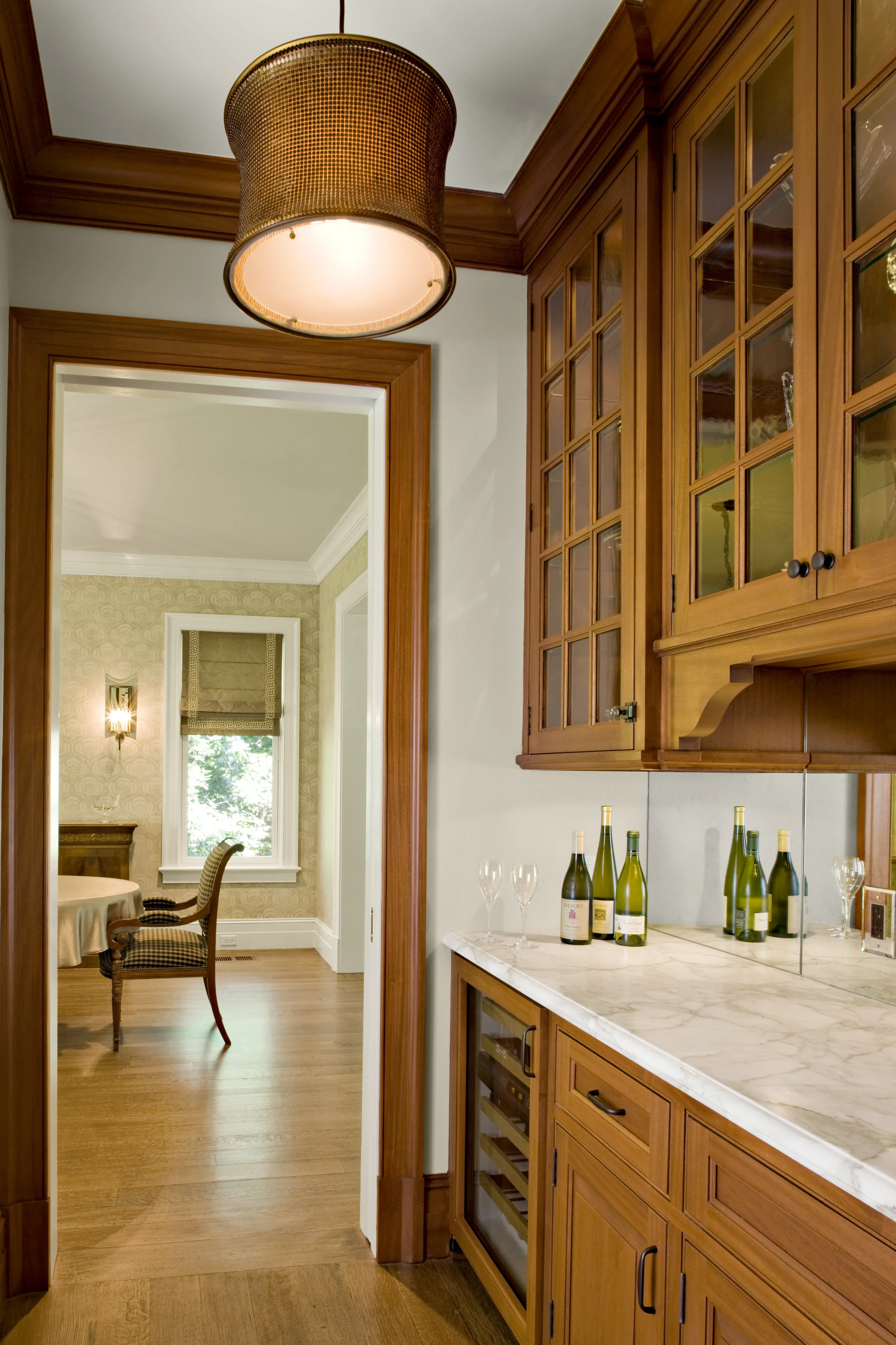 This is the Butler’s Pantry between the Kitchen and Dining Room. We designed custom mahogany cabinetry and a Calacatta gold counter to match the island in the kitchen. The backsplash is a lightly antiqued mirror. In the Dining Room the walls were stenciled by a specialty paint company. The stencil was sized for the height of the room, so that the baseboard and crown moulding assembly would not cut off the pattern. This process was a 6 step process to produce the background in a linen finish, and a mix of plaster and paint for the stencil. The wood flooring is a beautiful rift & quarter sawn white oak in long boards. In standard construction, wood floors are nailed to formaldehyde emitting underlayment and then finished with solvent-based finishes that will off-gas for months. In this project, old-fashioned, solid 1x8's were installed diagonally over the framing for the subfloor (instead of plywood), "dustless" sanding with a HEPA vacuum was specified to the floor installer and a solvent-free floor finish was used.