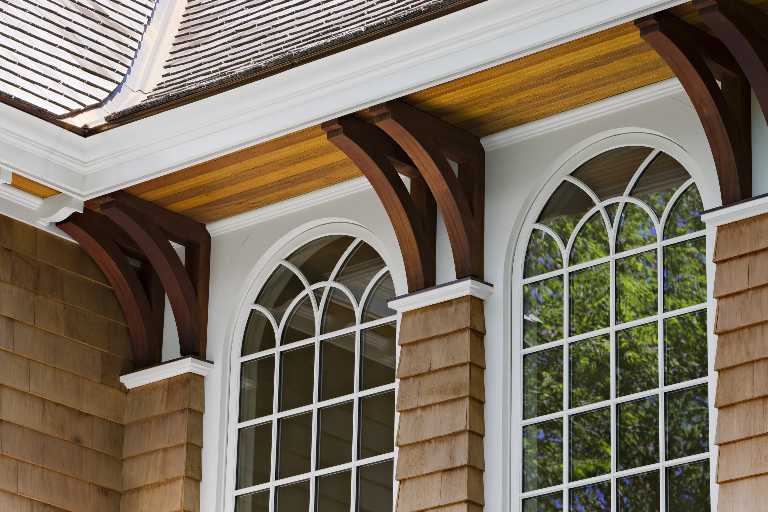 This is an image of the same windows at the second floor landing, but from the exterior. Here we designed shingle pilasters to give the custom mahogany brackets a base to sit on. The white trim here was simplified down to a flush panel, so that fussy trim details would not take away from the custom windows. Because the typical (pink) fiberglass insulation can release particulate matter and formaldehyde gasses, and must carry a warning label "probably human carcinogen", we researched alternatives to the typical insulation package. The insulation package throughout the house consisted of a spray foam insulation that encompassed the shell of the building (roof, exterior walls & floors at the overhangs). The spray foam insulation that we used is free of formaldehyde, CFC's and HCFC's. On the interior we used a formaldehyde-free, natural fiber insulation made mostly of recycled cotton/denim. The result is a very tight, well insulated and sound controlled home.