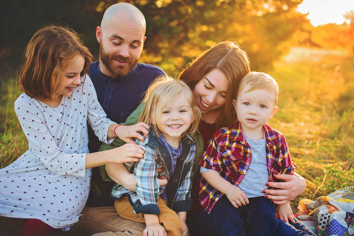 Fun and relaxed family portrait features golden hour sunlight.