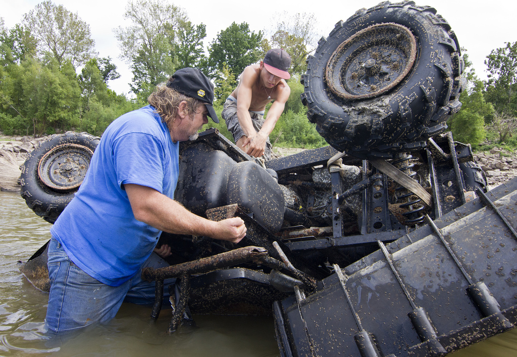 Archie Busby, left, of Cairo, Ill., and Pierre Hayden, of Cape Girardeau, Mo., salvage a flipped over all-terrain vehicle on Sept. 2, 2013 in the Mississippi River. The vehicle was allegedly ran into the river and abandoned.