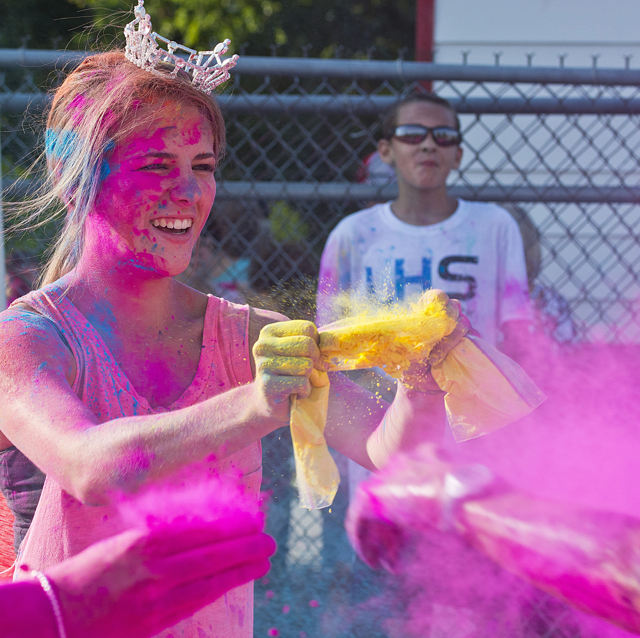 Haley Johnson, 16, of Pinckneyville, Ill., helps douse participants with color powder during the "Color Me for Light" 5K Run on Sept. 1 at the Williamson County Fairgrounds in Marion, Ill.
