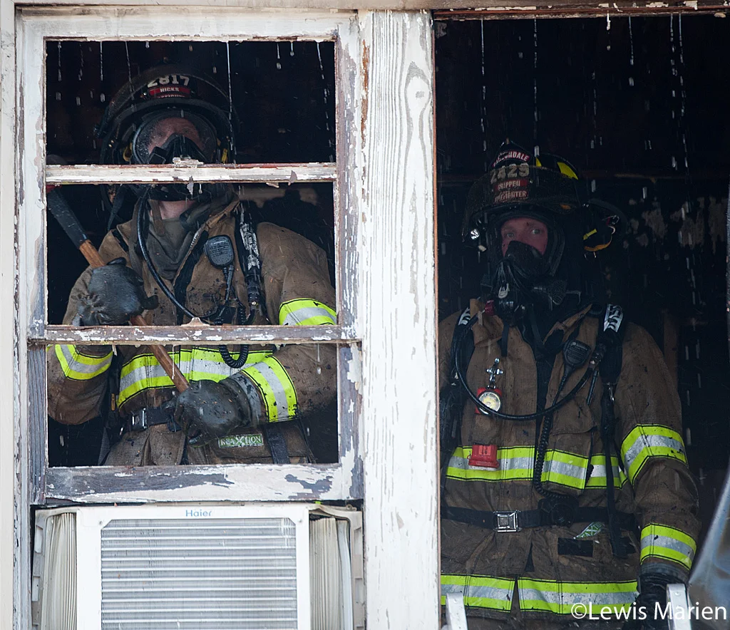 Carbondale Fire Department firefighters Chad Hicks (left) and Jay Crippen (right) work to put out the remains of a house fire at 208 W. Hospital Drive in Carbondale.