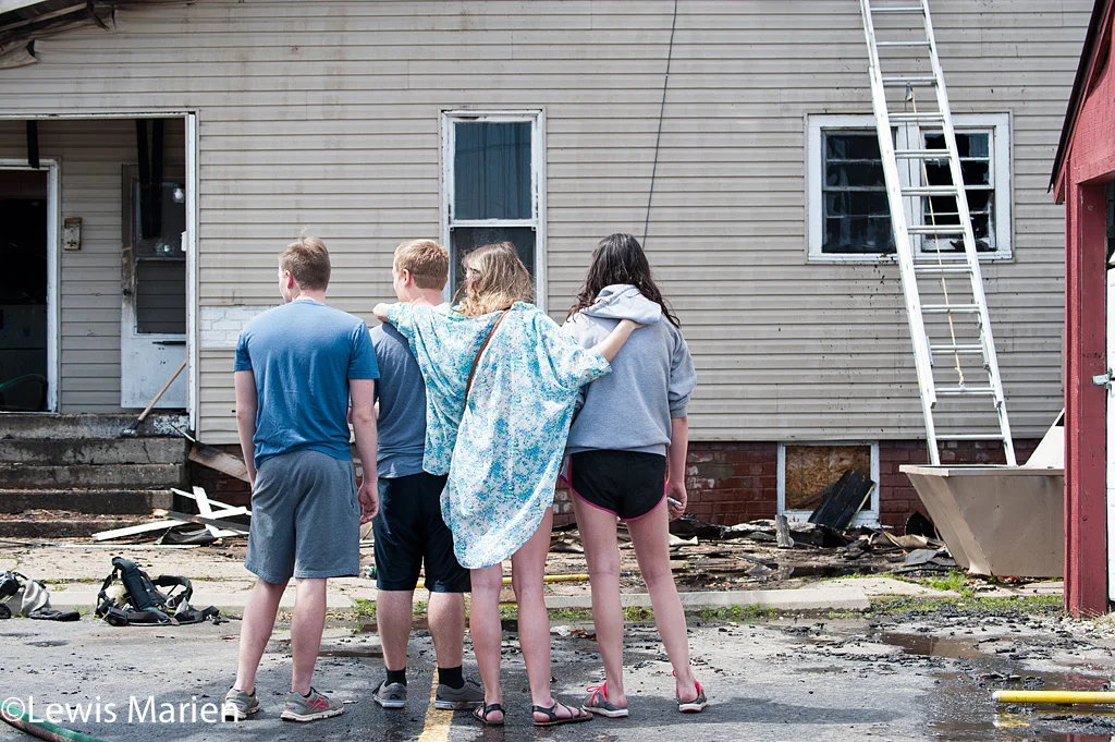 Residents watch the Carbondale Fire Department put out the remains of a house fire at 208 W. Hospital Drive in Carbondale.