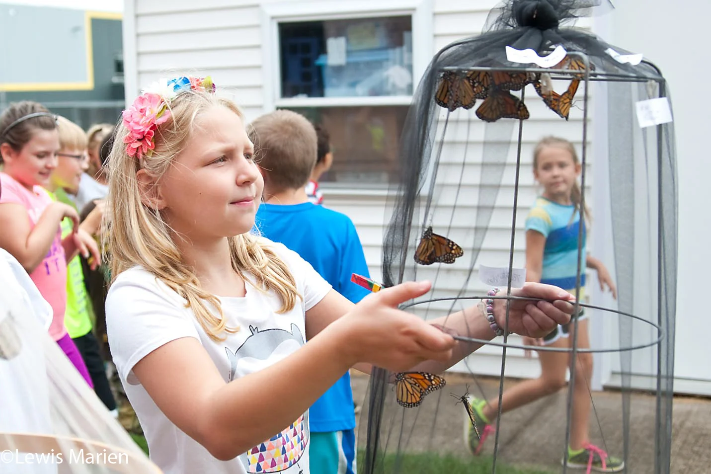Bailey Ripka, 9, carries a basket filled with monarch butterflies near Gale Elementary School in Galesburg, Ill., on Sept. 8. Students at the school released more than 70 monarch butterflies which are migrating to Mexico for the winter.