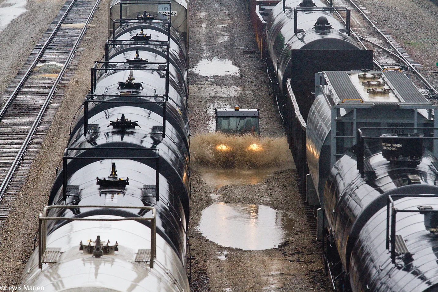 An all-terrain vehicle navigates through big puddles between tracks Nov. 17 at the BNSF Railway yard in Galesburg, Ill.