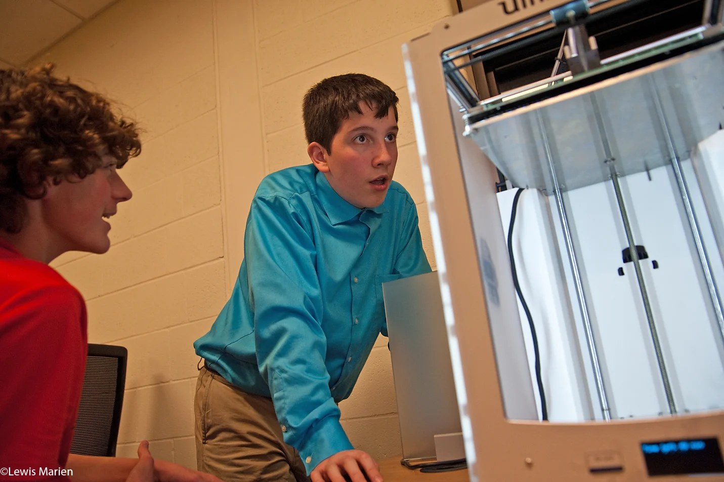 Knoxville High School freshmen Jacob Betz, left, and Steven Comandini watch a 3-D printer in action on Nov. 23. The high school in Knoxville, Ill., recently added two 3-D printers and started a robotics team.