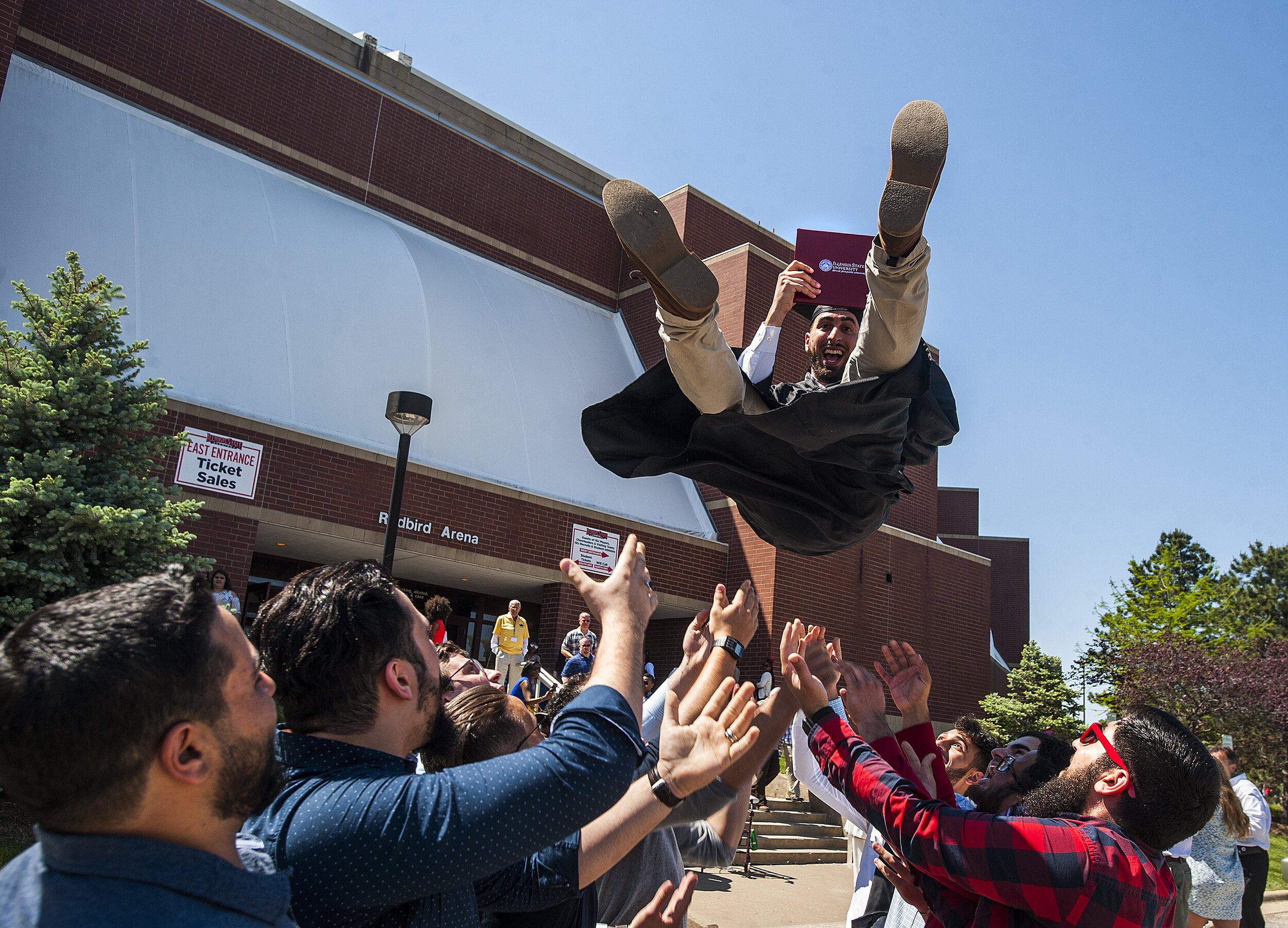  Illinois State University student Omar Qaddour, of Kansas City, Missouri, gets lifted into the air by friends as he celebrates his bachelor's degree in information technology following the 158th annual commencement for the College of Applied Science