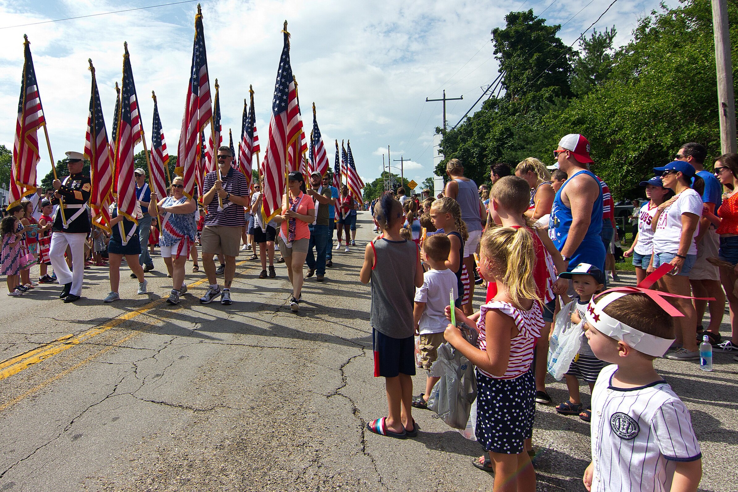  Walkers tote U.S. flags to lead off a Fourth of July parade Thursday, July 4, 2019, in Towanda, Illinois. The celebration has been a tradition in the McLean County village since 1969. 