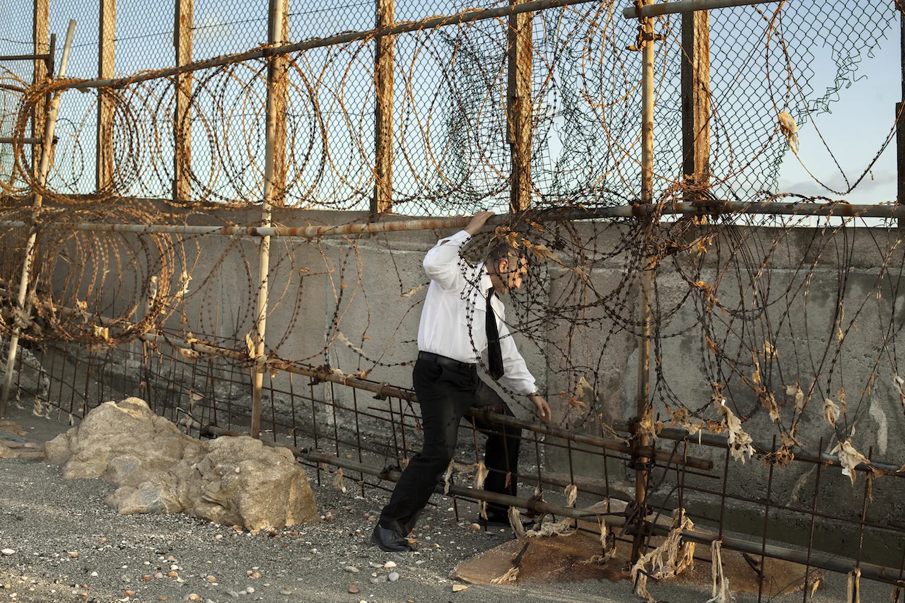 The Fence of Gibraltar, British Overseas Territory of Gibraltar, 2016 A British customs officer checks the hole made by tobacco smugglers in the border fence that separates the UK from Spain Photograph: Arnau Bach