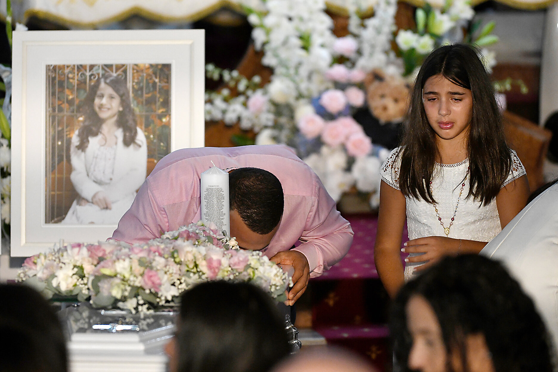  Danny Adballah is seen kissing the coffin of one of his children, as his surving daughter watches on, during the funeral for siblings Antony Abdallah, 13, Angelina Abdallah, 12, and Sienna Abdallah, 8, at Our Lady of Lebanon Co-Cathedral in Sydney, 