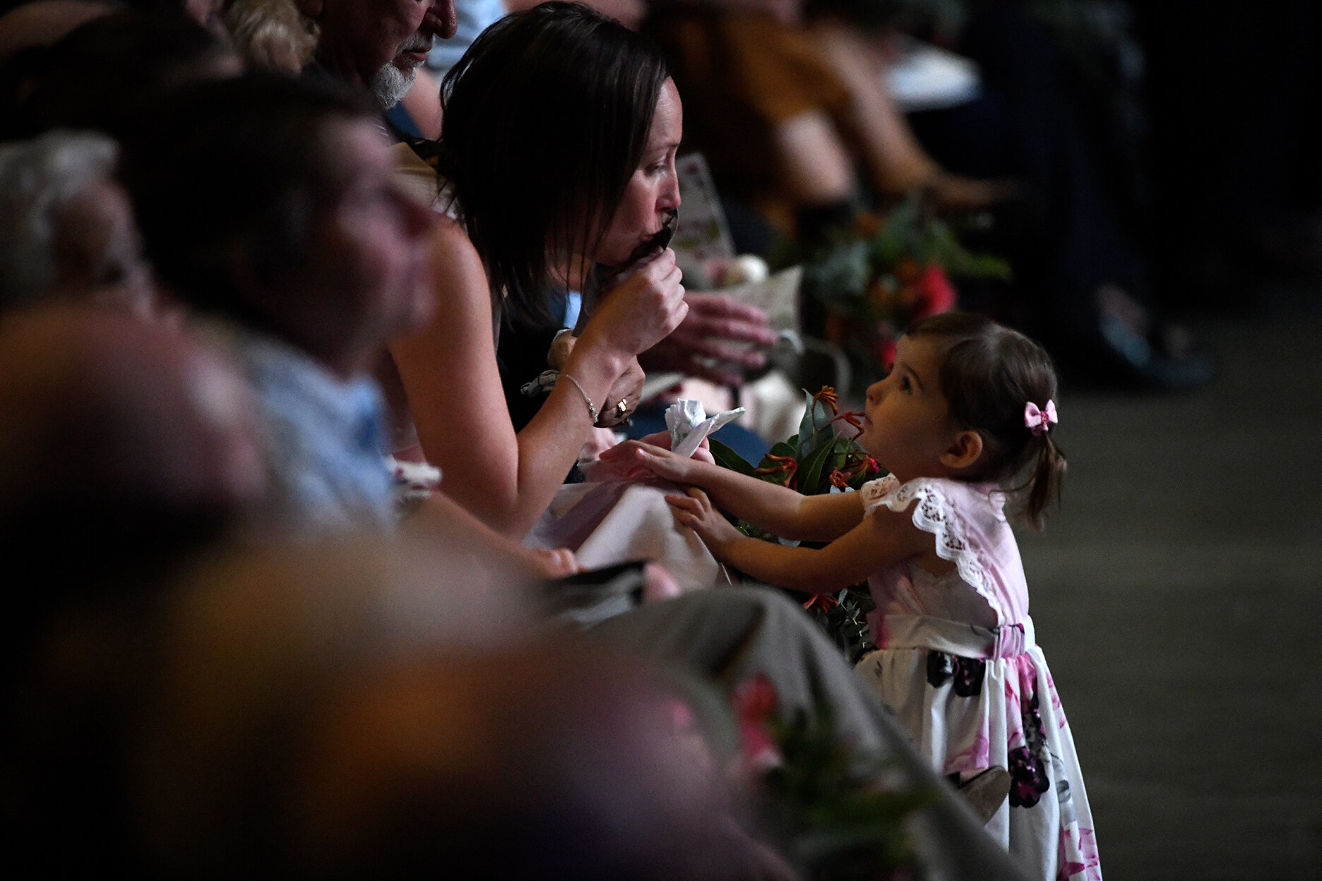  Widow Melissa O'Dwyer kisses a photo of husband RFS volunteer Andrew O'Dwyer as daughter Charlotte looks on during a Bushfire State Memorial at Qudos Bank Arena in Sydney, Sunday, February 23, 2020.  Volunteer firefighters Geoffrey Keaton, 32, and A