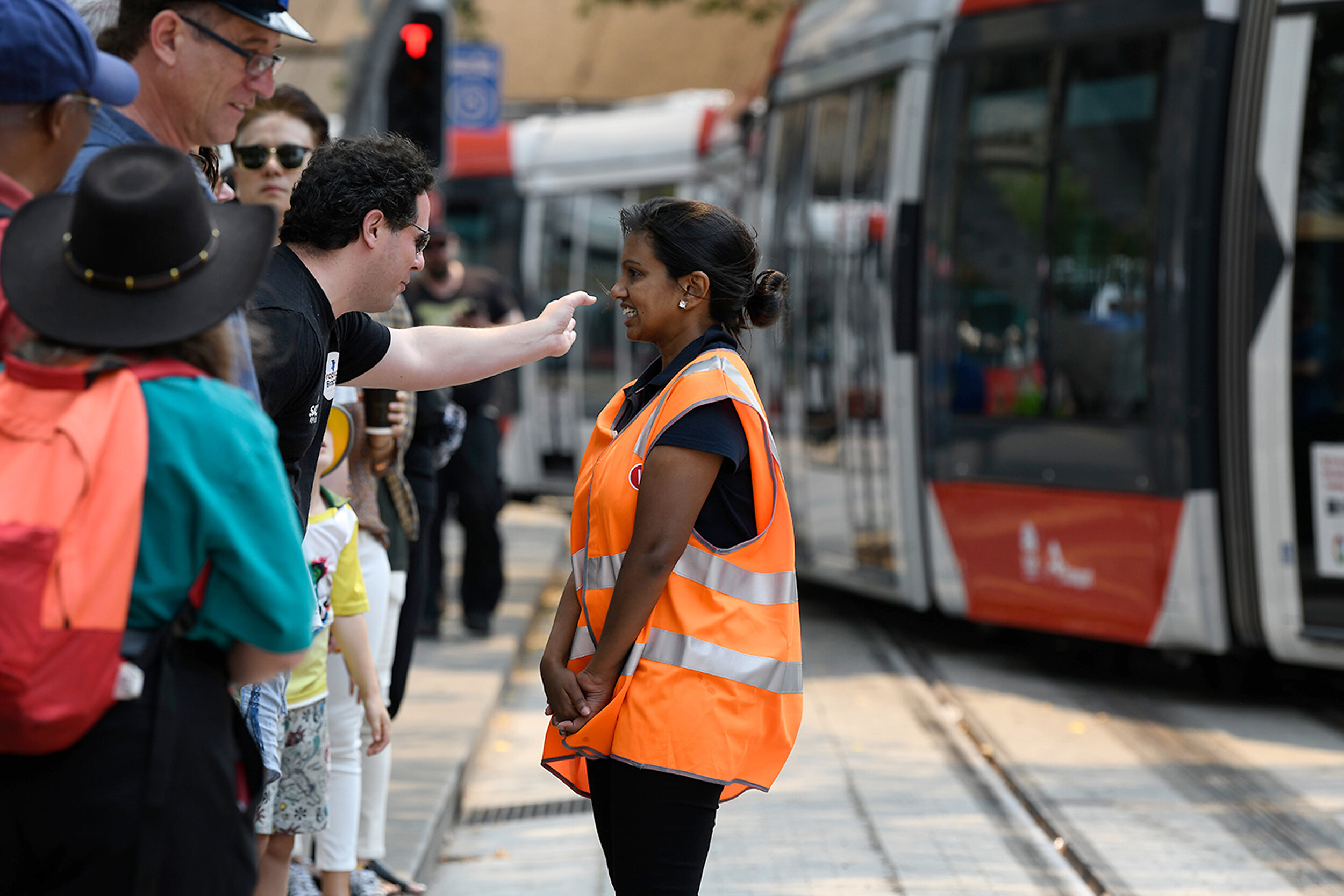  A light rail worker speaks to a member of the public after a tram became suck on the track at Circular Quays in Sydney, Saturday, December 14, 2019. Sydney's CBD light rail system has broken down just hours after the new service began taking passeng