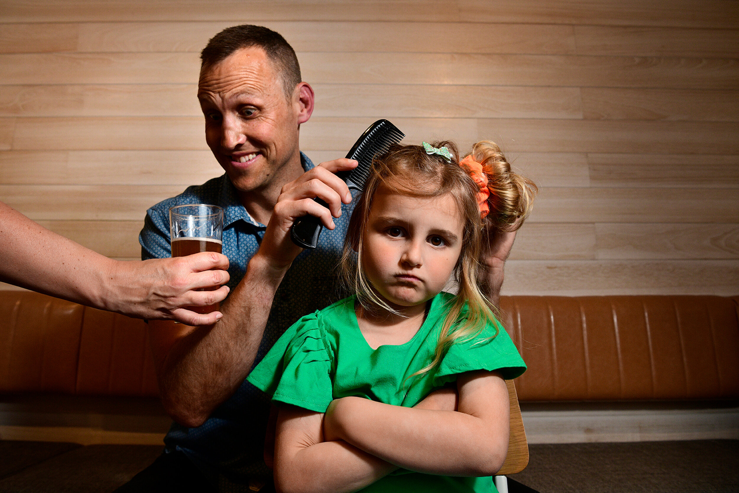  5.9.18- Lulu, 6, waits patiently as her dad Daniel Wakelin tries to do her hair at The Moseley, Glenelg. The father-daughter duo will take part in the 'Daddy-Daughter Haircare Day' on September 15th at both The Moseley and The Gully pubs, where dads