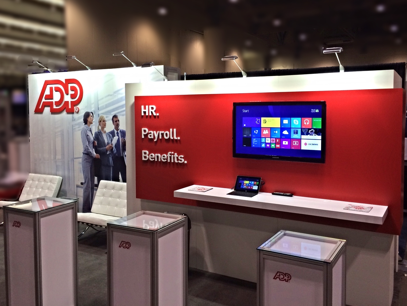 ADP Canada's red and white exhibition booth design is a combination of custom wall panels and our exhibit display system Octanorm.