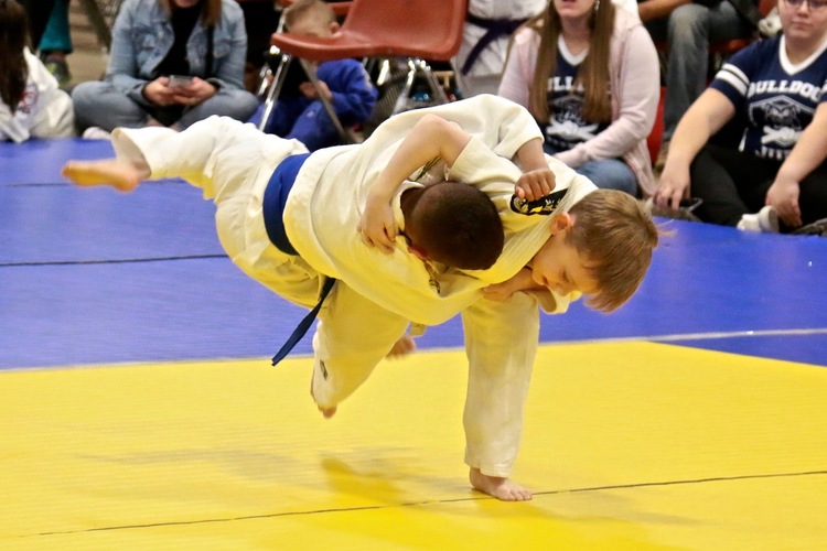 a hip throw in a kids' martial arts competition