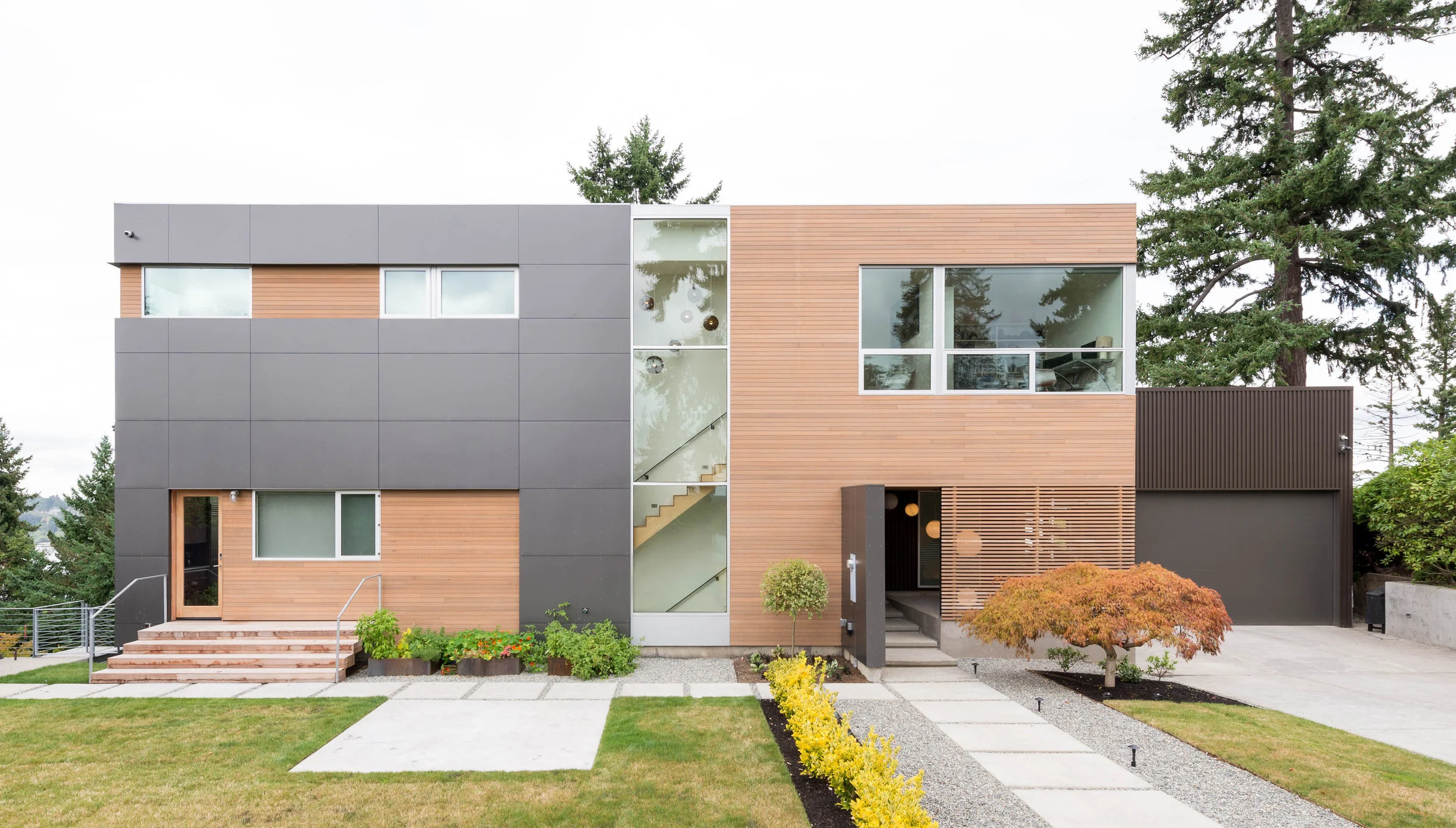 Bellevue, Washington Perched to capture views of Seattle, the Puget Sound, the Olympic Mountain Range and Mount Rainier this substantial remodel of an existing home focuses on sightlines, natural light, and indoor-outdoor relationships. Because an existing foundation is reused in a steep slope area, the new work maintains the line of the existing footprint and maximizes vertical expansion. A simple massing keeps the structural system straight-forward and cost-effective, while a disciplined interior and thoughtful detailing create a timeless envelope. The floor plan takes full advantage of a striking site while accommodating all the needs of a growing family. All images by BUILD LLC.