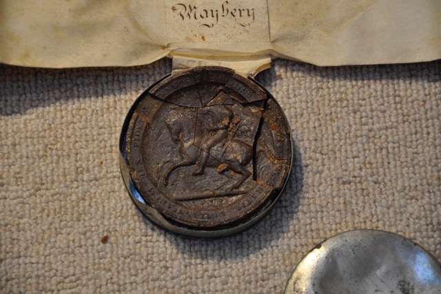 damaged seal in metal container for the Manor of Hay