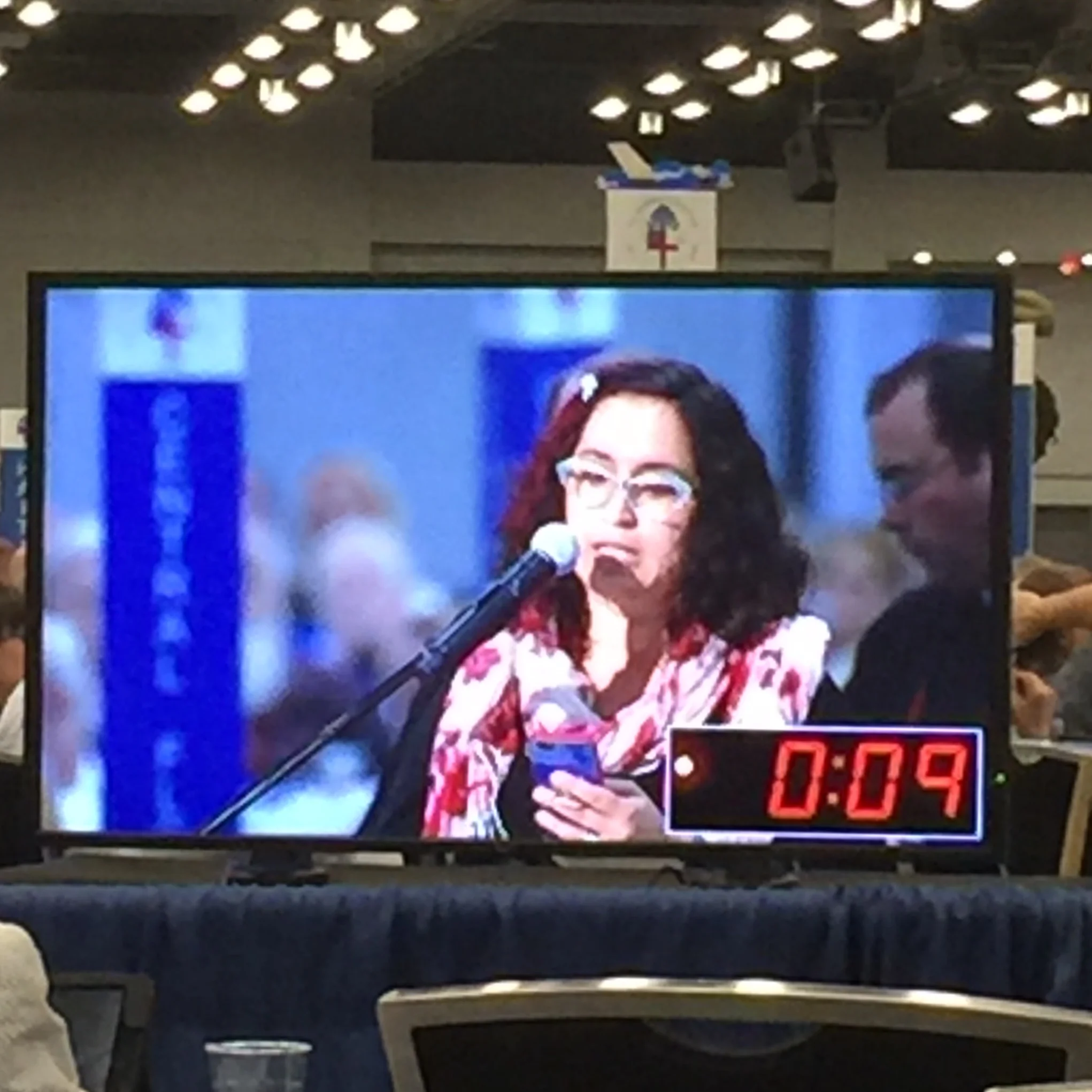 If you are an alternate or visitor, there are large tv monitors positioned around the edges. Each speaker on the floor is allowed 2 minutes to share their support or opposition to a resolution. When the timer is done, the video stream ends and the President of the House of Deputies politely tells him/her the time is up.