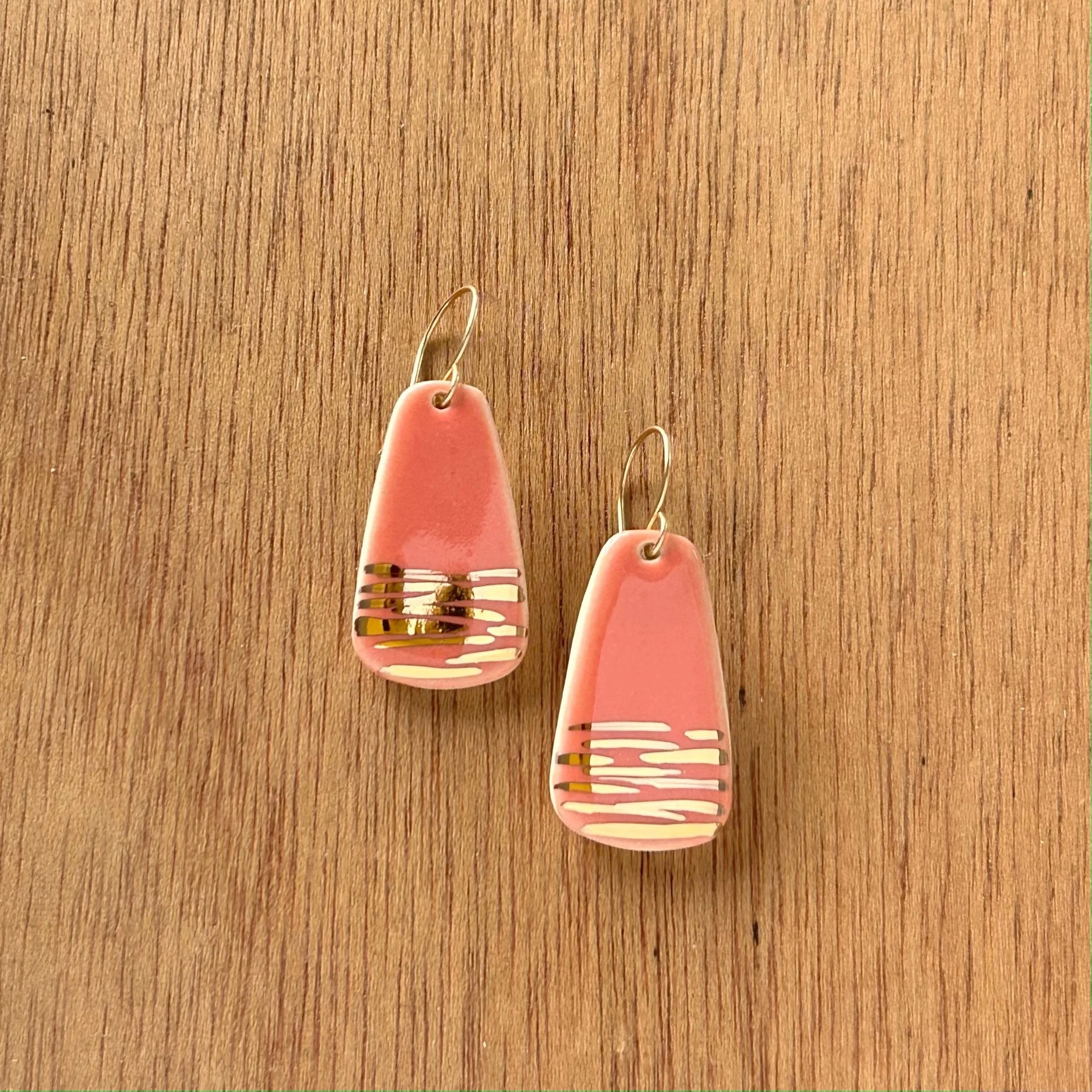 ZOE%CC%88+COMINGS+large+fan+earrings+coral%3Agold+stripe+wdbkg.jpg